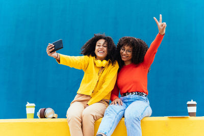 Young woman with friend taking selfie