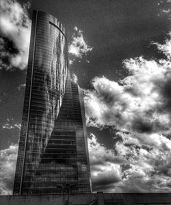 Low angle view of modern building against cloudy sky