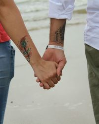 Low section of couple holding hands