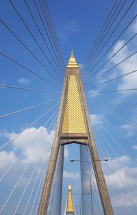 Low angle view of suspension bridge against sky