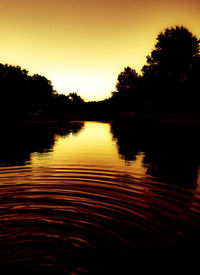 Scenic view of lake against clear sky during sunset