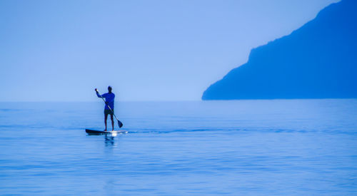 Man surfing in sea against clear sky