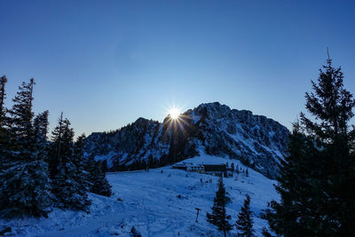 Scenic view of snow covered mountains against clear blue sky