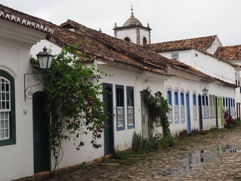 Exterior of house by building against sky