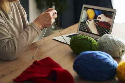 Midsection of woman using laptop on table