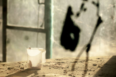 A still life image with an old plastic mug on a devastated table. 