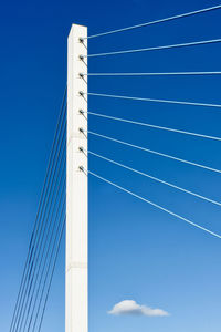 Low angle view of suspension bridge against blue sky