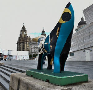 Statue of building in city against clear sky