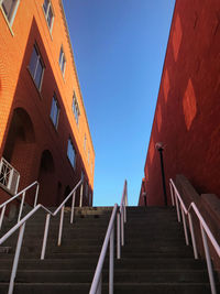 Low angle view of steps amidst buildings against clear sky