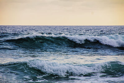 Scenic view of waves splashing in sea