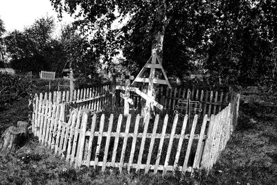 Wooden fence on field by trees