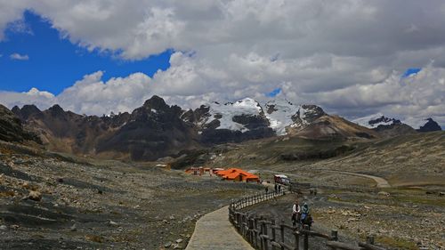 People on mountain range against sky