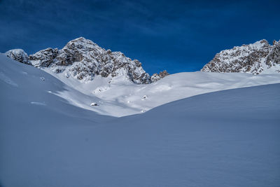 Scenic view of snowcapped mountain against blue sky