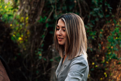 Smiling young woman looking away in forest