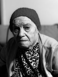 Close-up portrait of senior woman sitting on sofa at home