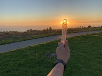 Midsection of person against sky during sunset