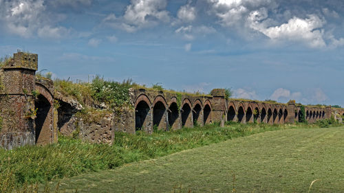 Old ruins on field against sky