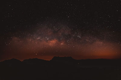 Low angle view of silhouette mountain against sky at night