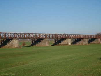 Bridge over field against clear sky