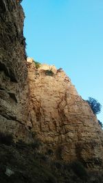 Low angle view of rock formations against clear blue sky