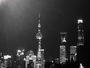 Illuminated buildings in city against sky at night