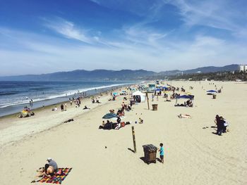 People at beach against blue sky