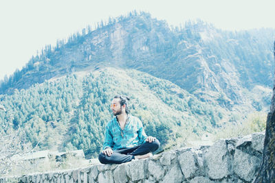 Young man sitting on mountain