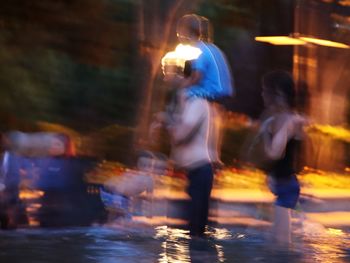 People on wet street in city at night