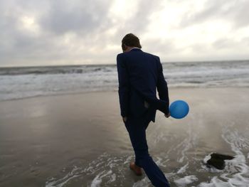 Rear view of a man standing on beach