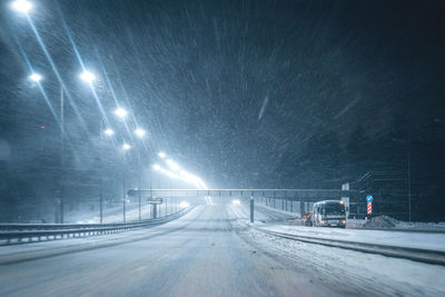 Road on snow covered street at night