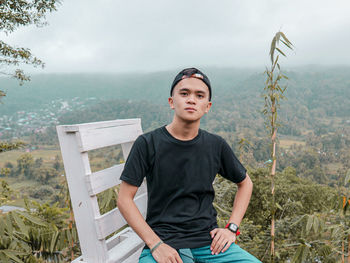 Portrait of a young man sitting on land