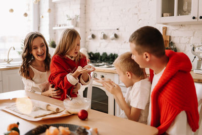 Family with children having fun and laughing while preparing for the christmas holiday in kitchen