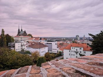 Buildings in town against cloudy sky