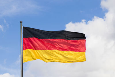 Low angle view of flag against sky, germany flag.on the blue sky background 