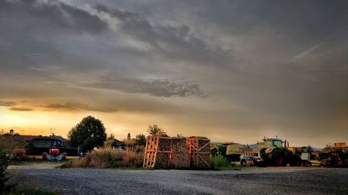 Cars on road against sky at sunset