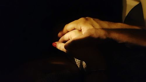 Close-up of hands against dark background