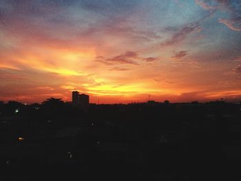 Silhouette of building against dramatic sky