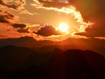 Scenic view of silhouette mountains against romantic sky at sunset