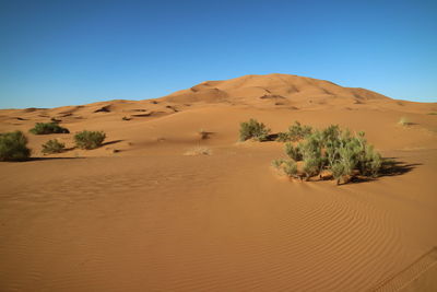 Scenic view of desert against cloudy sky