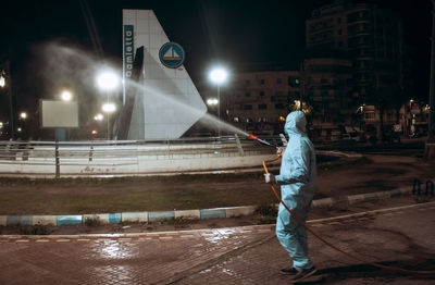 Man standing on street at night