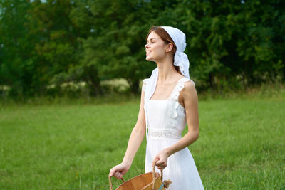 Portrait of young woman standing in park