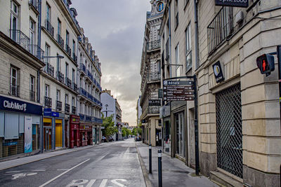 Empty road amidst buildings in city