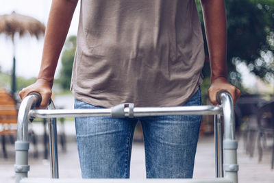 Rear view of woman standing on railing