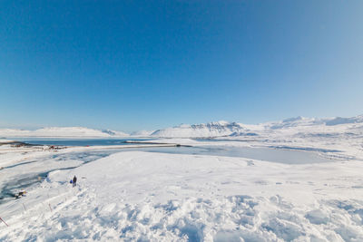 Scenic view of snowcapped landscape against blue sky