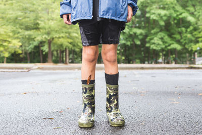 Low section of child wearing boots