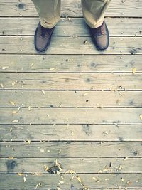 Low section of man standing on boardwalk