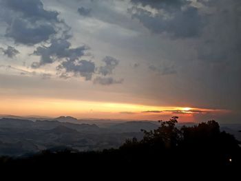 Scenic view of silhouette mountains against orange sky