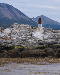 Lighthouse by sea against sky