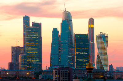 Skyscrapers in city against cloudy sky