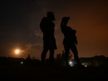 Silhouette people standing against sky during sunset